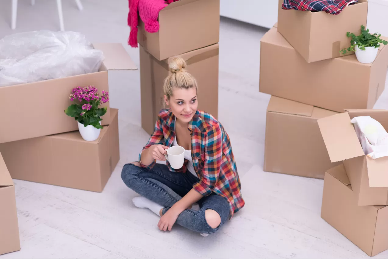 A young woman surrounded by moving boxes