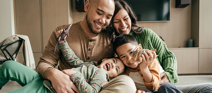 Family embracing on couch and smiling